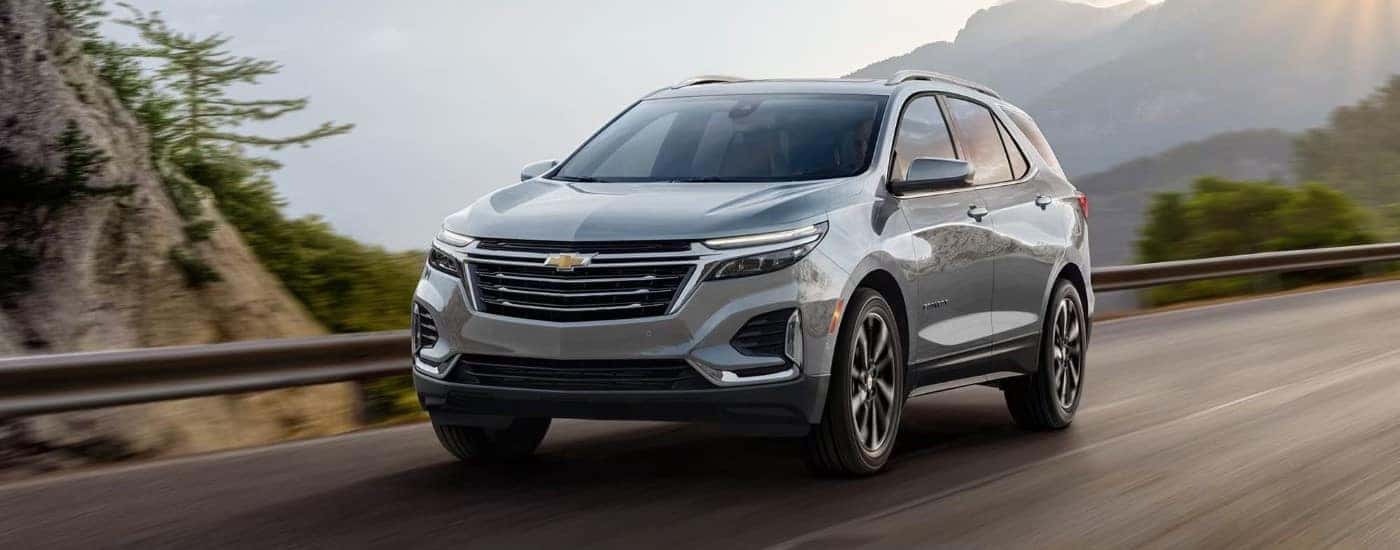 A silver used 2024 Chevy Equinox driving on a highway