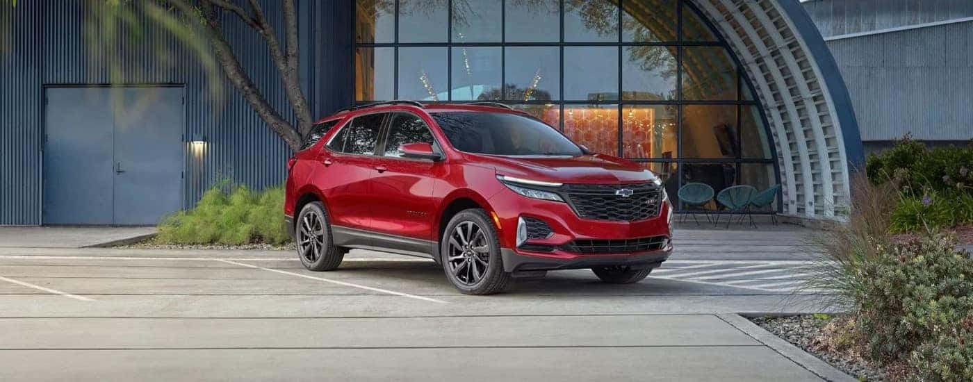 A red used 2024 Chevy Equinox RS parked outside a building