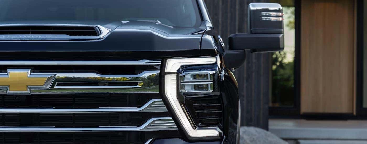 Front grille of a black Chevy Silverado 2500 parked in a driveway
