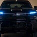 A black 2025 Chevy Silverado EV charging in a garage