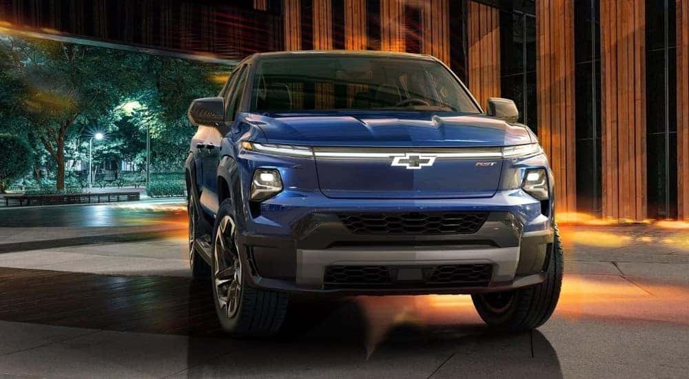 Head on view of a blue 2025 Chevy Silverado EV parked in front of a building.