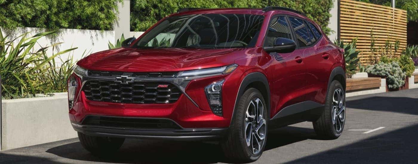 A red 2025 Chevy Trax RS parked in a city.