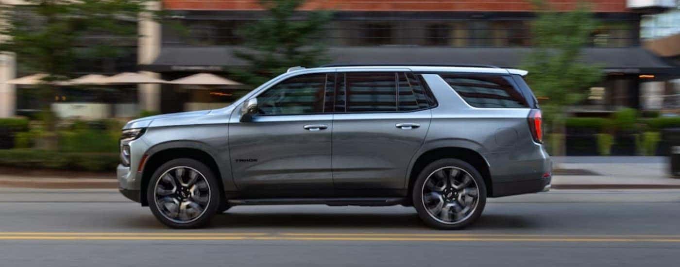 A silver 2025 Chevy Tahoe driving to a Chevy dealer near Guilderland.