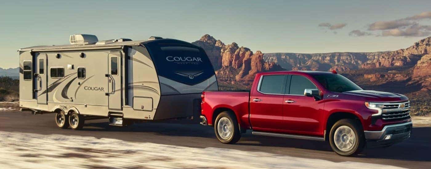 A red 2025 Chevy Slverado 1500 Z71 towing a trailer.