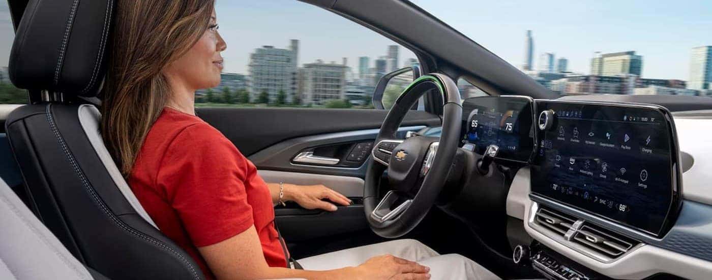 A person driving in a 2024 Chevy Equinox EV for sale near Niskayuna.