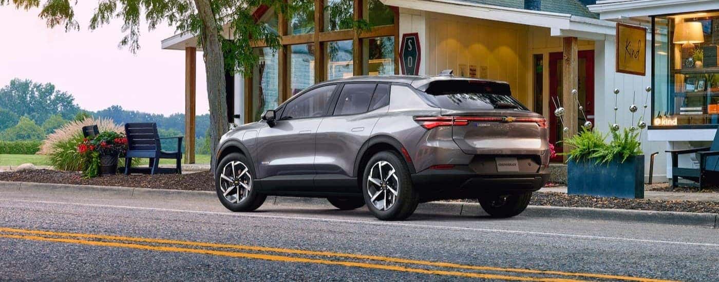 A silver 2024 Chevy Equinox EV parked in a city.