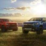 Two 2022 Chevy Colorados parked side by side in a field