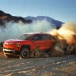 Red 2026 Chevy Silverado EV Trail Boss driving off road