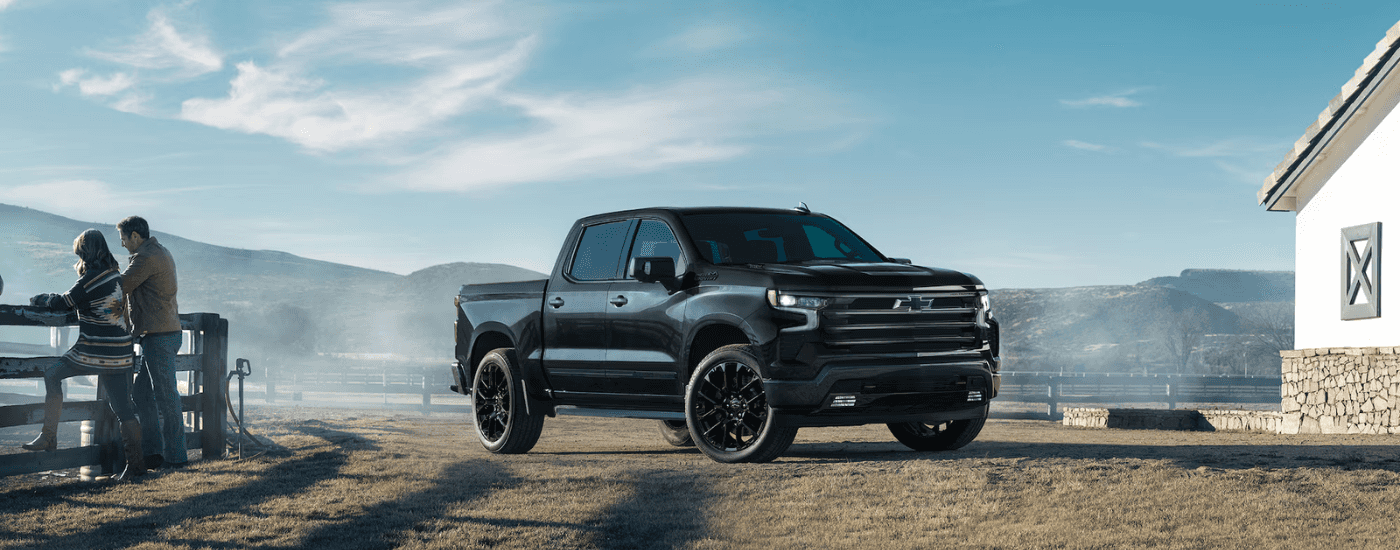 Black 2025 Chevy Silverado High Country for sale parked on a farm.