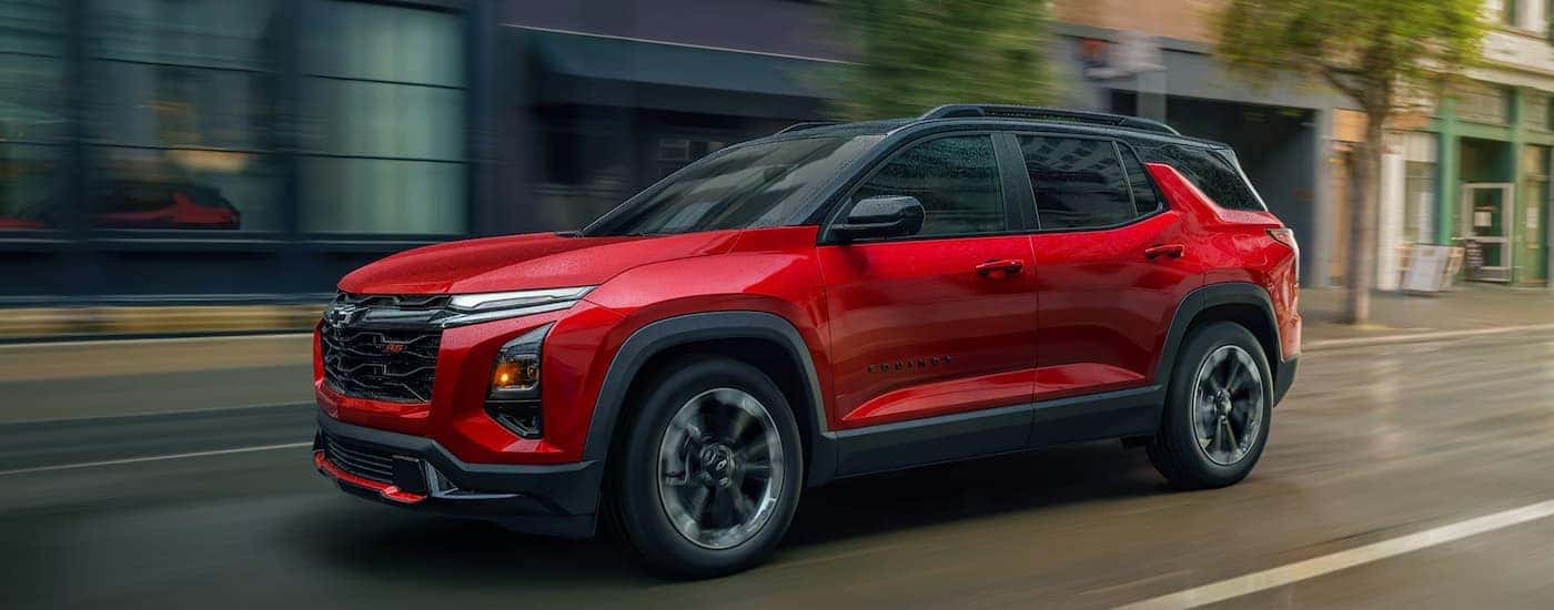 A red 2025 Chevy Equinox driving down a city street