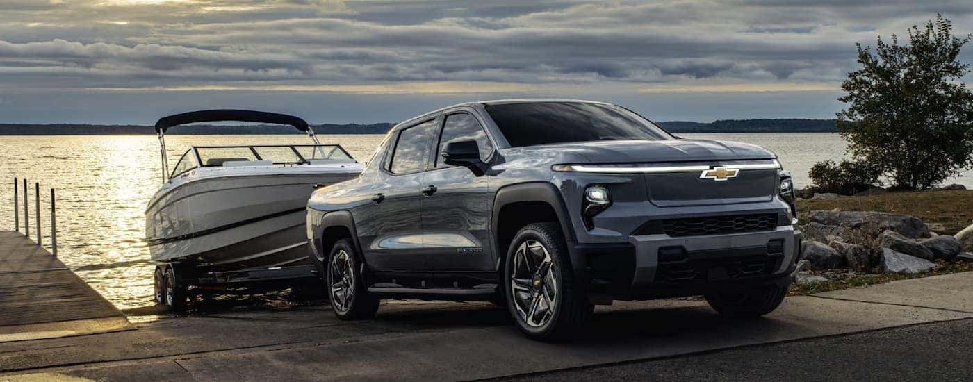 A gray 2026 Chevy Silverado EV towing a boat out of water
