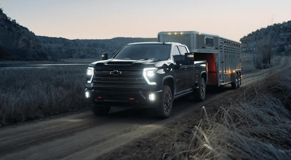 Black Chevy Silverado 3500 HD  towing a horse trailer