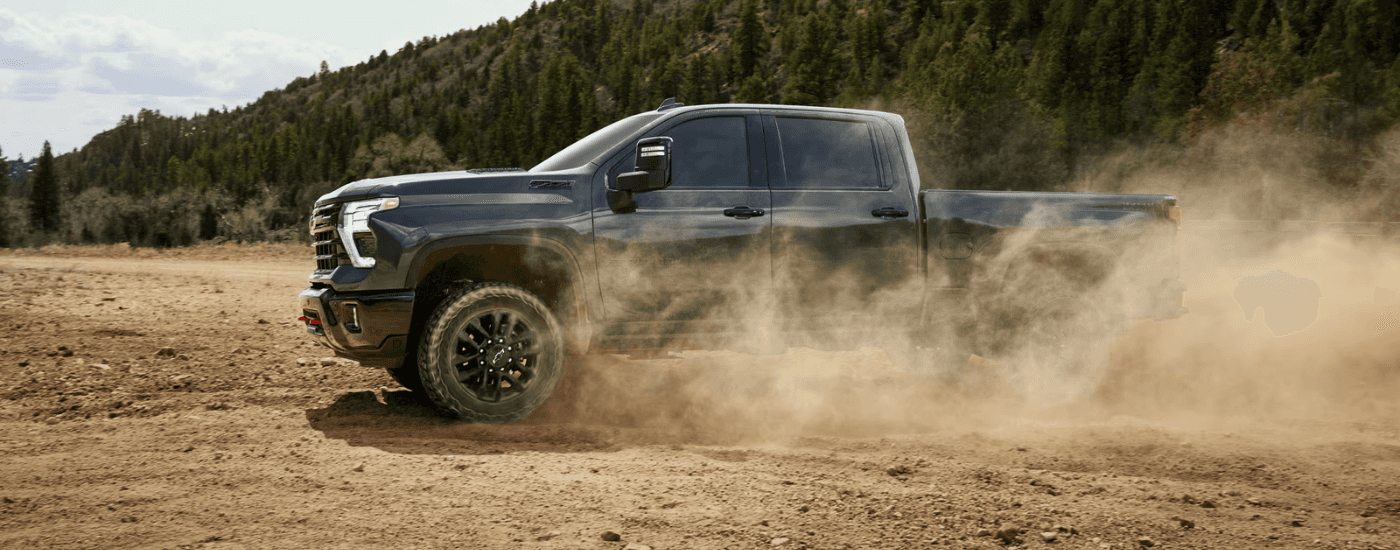 Green 2026 Chevy Silverado 3500 Trail Boss drifting off-road