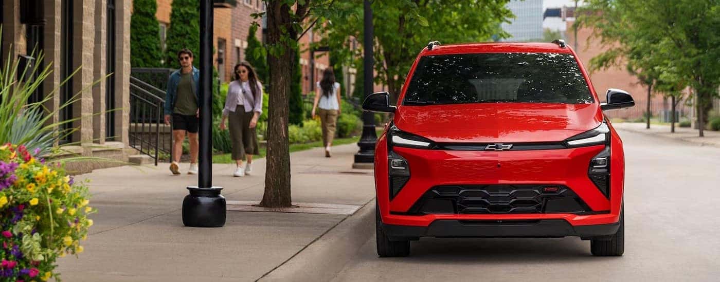 A red 2027 Chevy Bolt RS parked in a city.