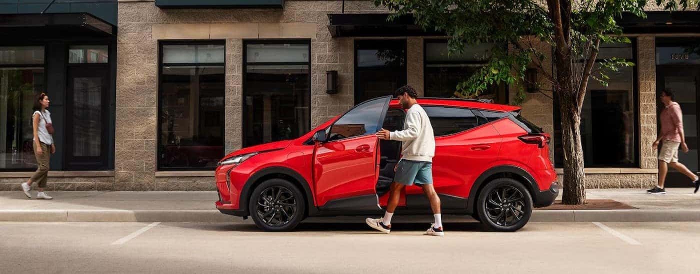 A red 2027 Chevy Bolt RS parked in a city.