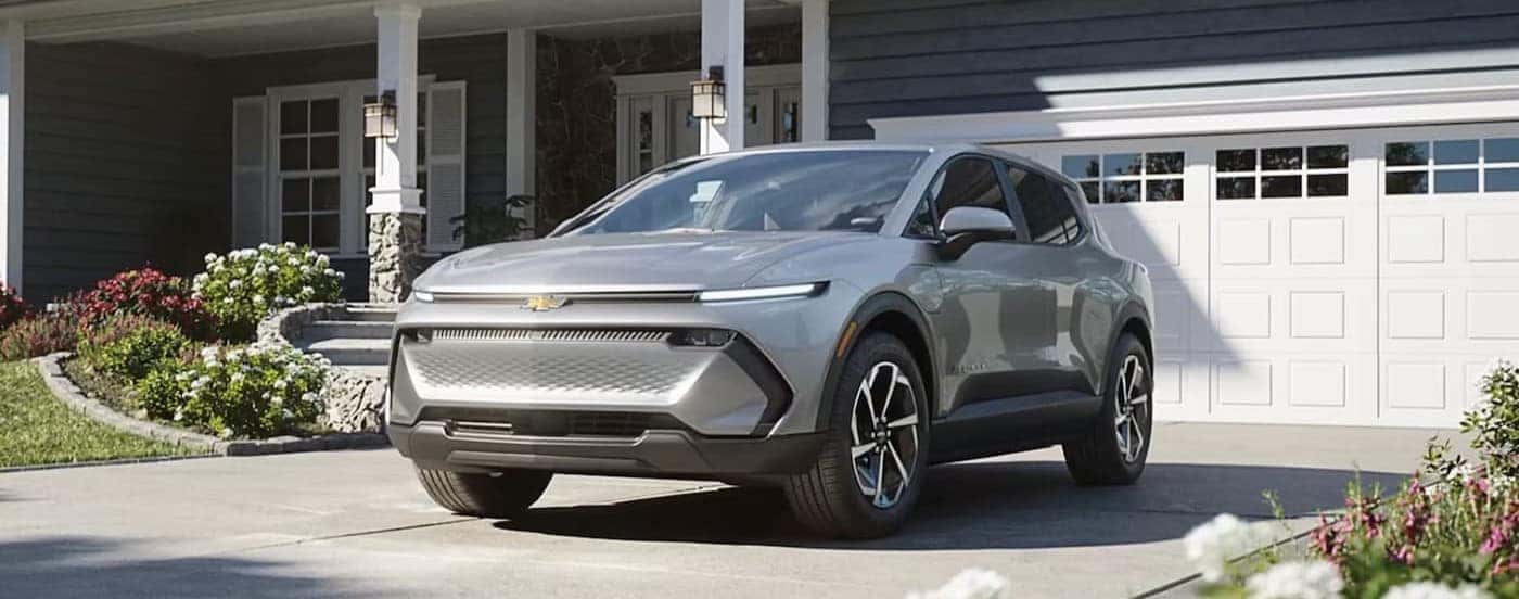 A silver 2026 Chevy Equinox EV parked on a driveway.