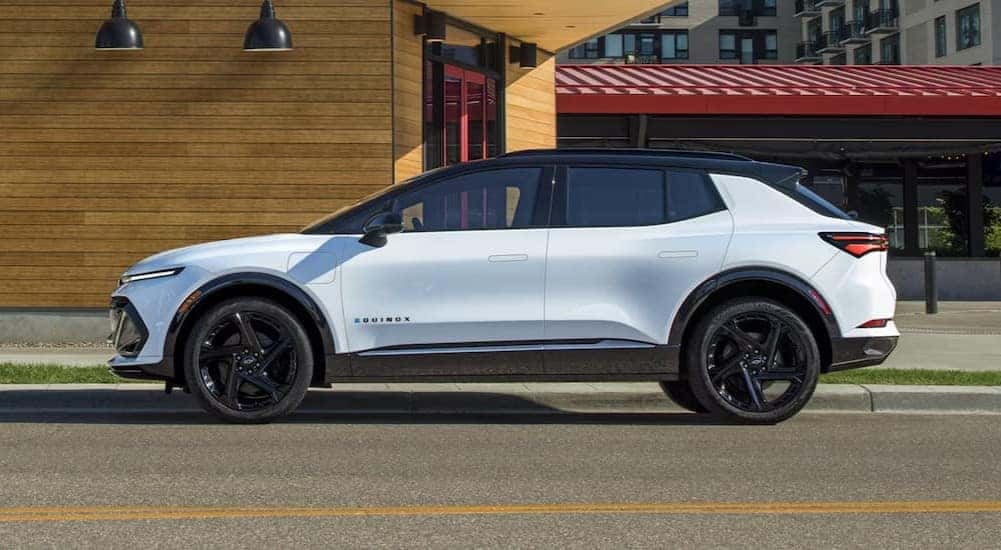 A white 2026 Chevy Equinox EV RS parked in a city.