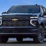 A blue 2026 Chevy Tahoe High Country parked near water.
