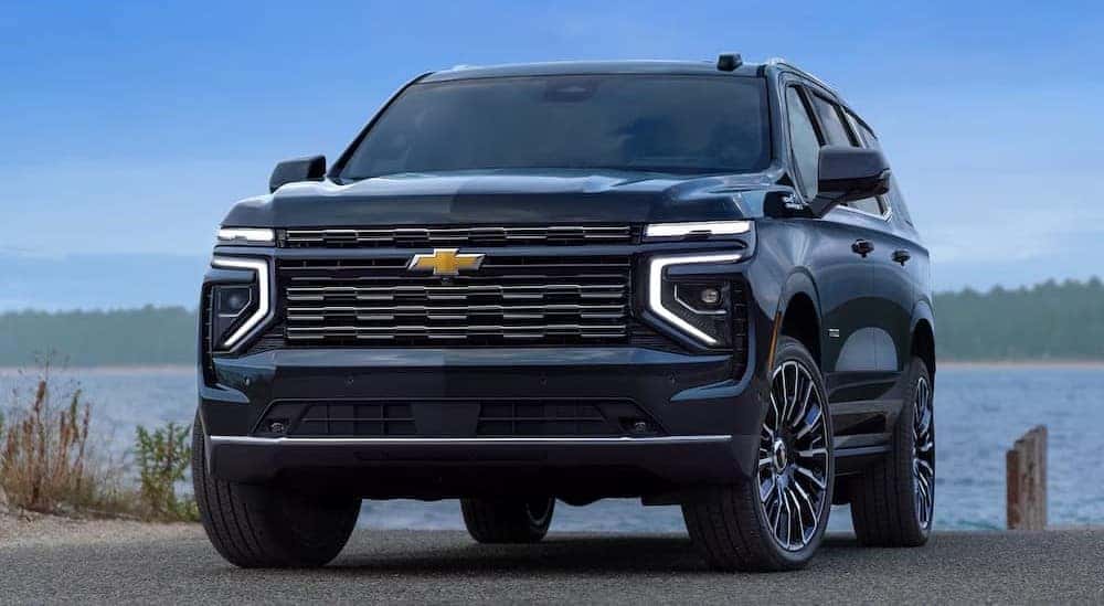 A blue 2026 Chevy Tahoe High Country parked near water.
