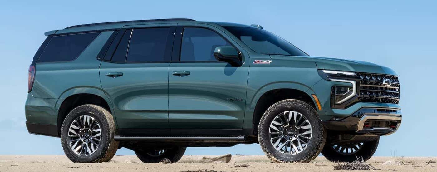 A green 2026 Chevy Tahoe Z71 parked on sand.