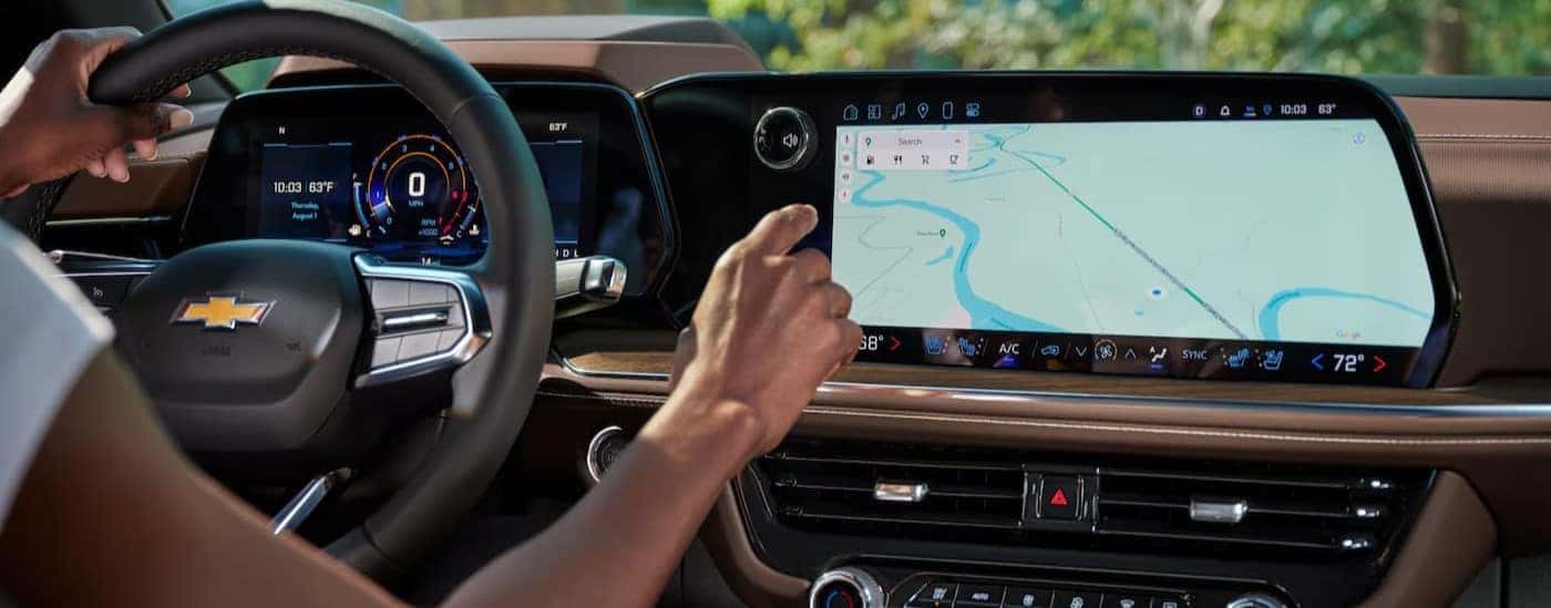 A person using the infotainment center in a 2026 Chevy Tahoe.