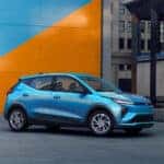 A blue 2027 Chevy Bolt from the side.