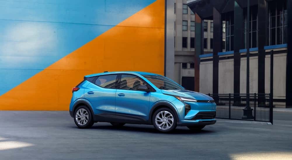 A blue 2027 Chevy Bolt from the side.