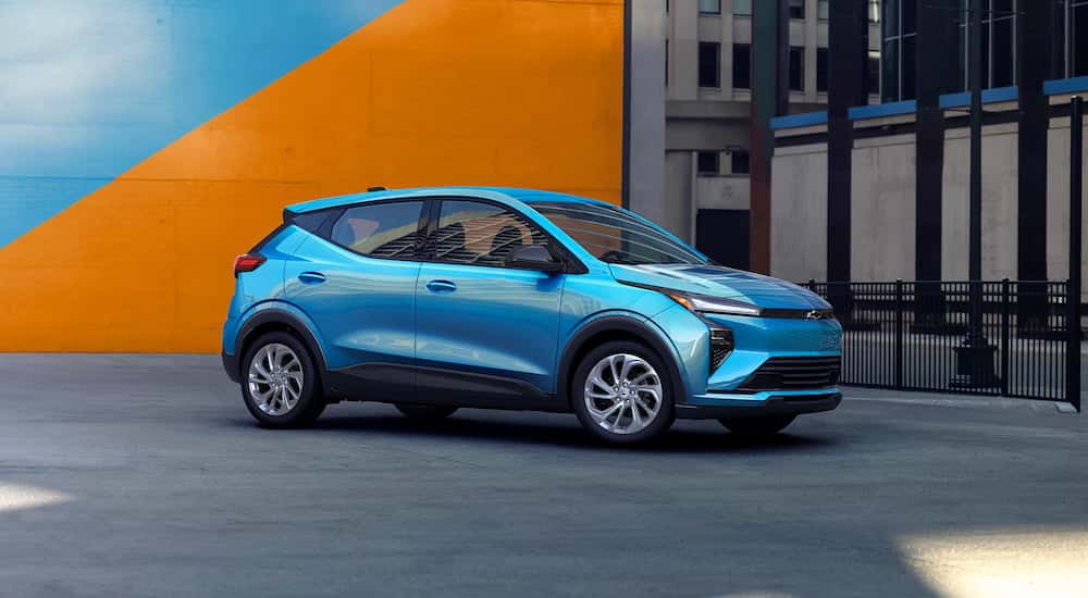 Blue 2027 Chevy bolt parked near a wall.