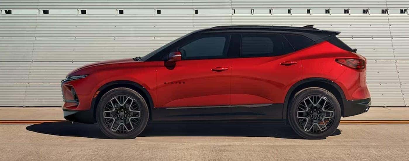 A red 2024 Chevy Blazer parked near a used car dealer near Schenectady.