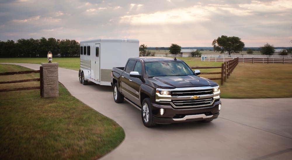 Black 2017 Chevy Silverado 1500 towing a camper.