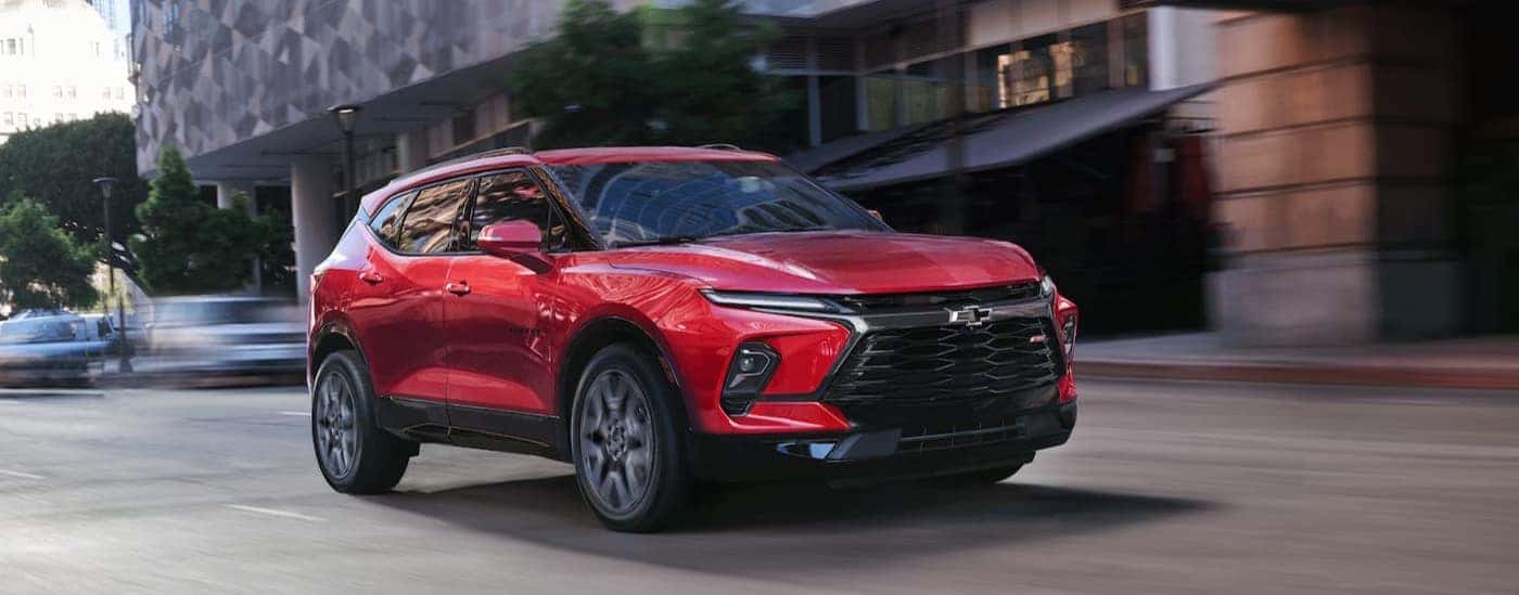 A red 2026 Chevy Blazer RS driving in a city.