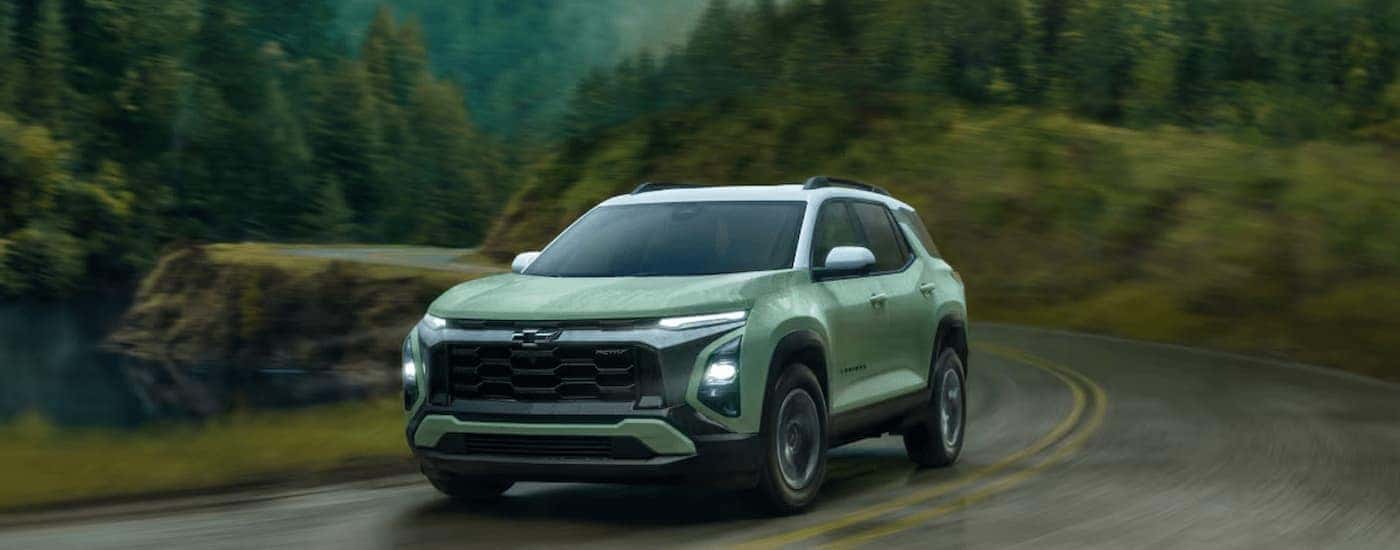 Green 2025 Chevy Equinox driving in the rain