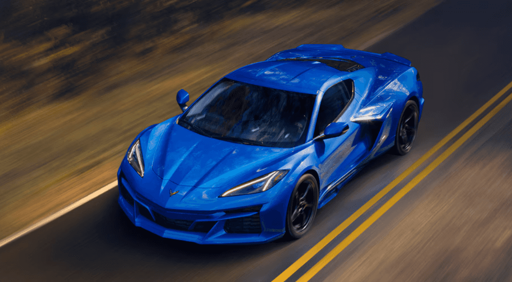 Blue 2026 Chevy Corvette E-Ray driving down a rural street