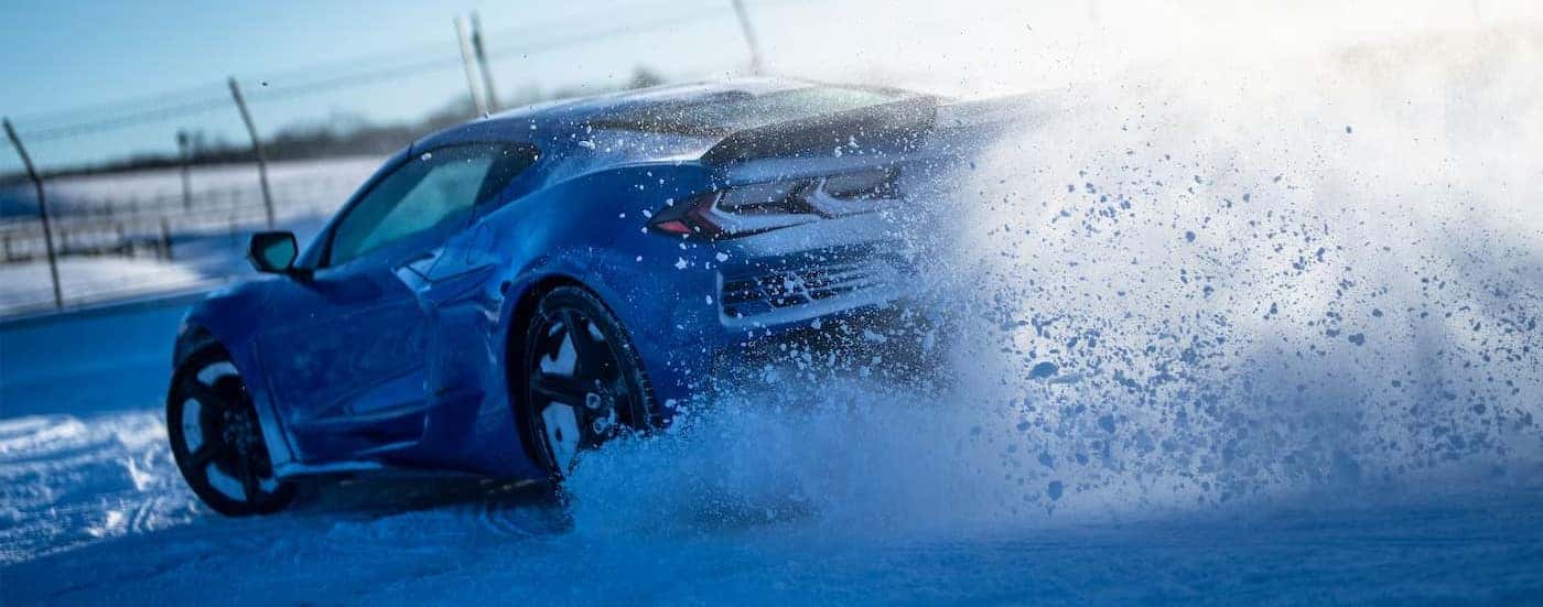 A blue 2026 Chevy Corvette E-Ray driving in snow.