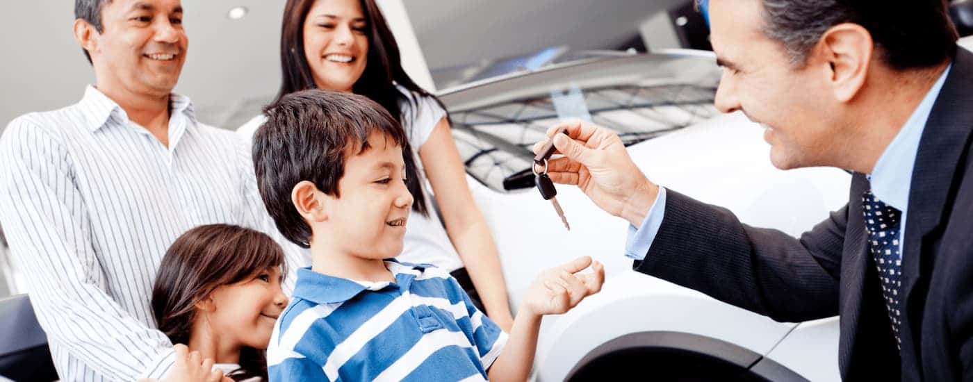 Salesman handing a key to a family