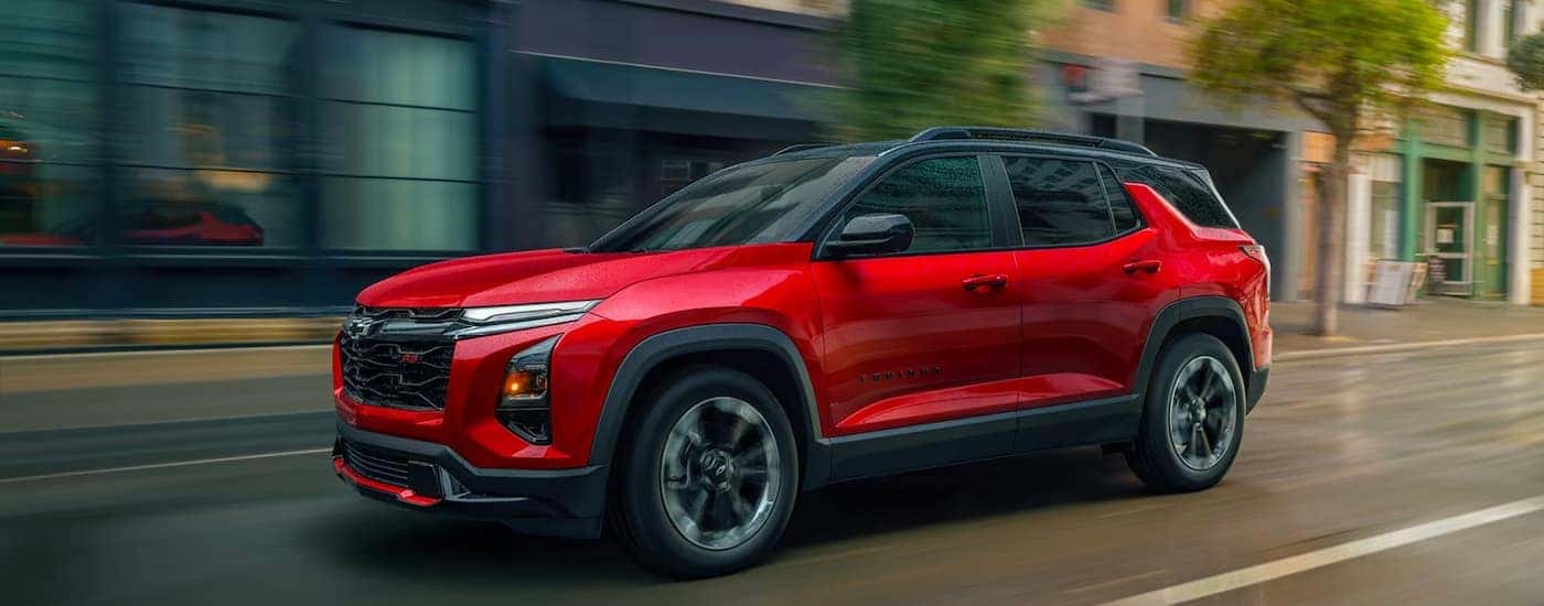 A red 2026 Chevy Equinox driving down a city street