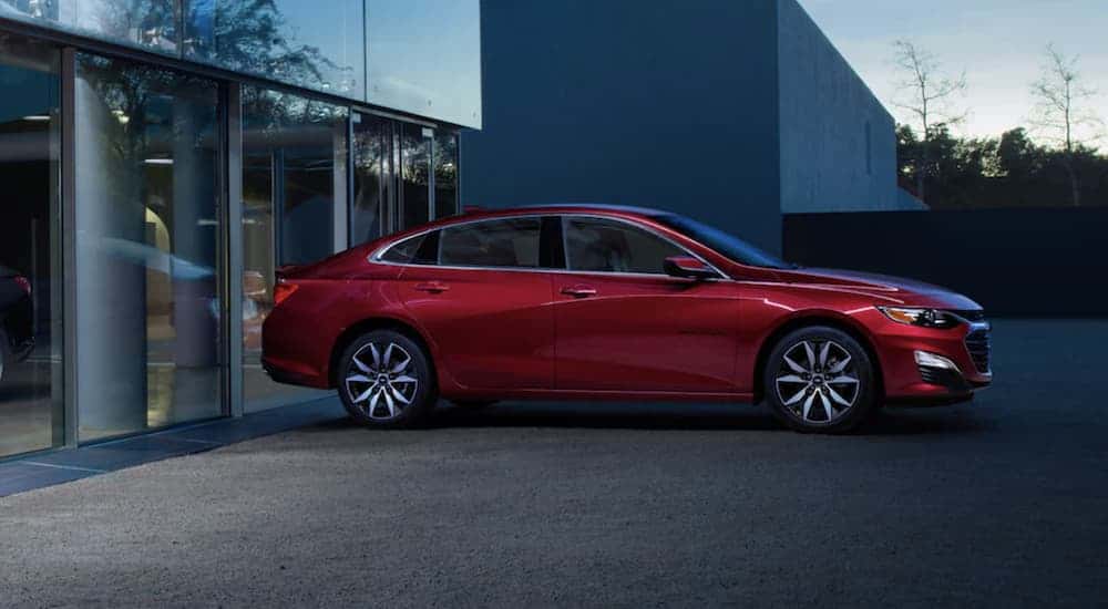Red 2022 Chevy Malibu backed up to a building