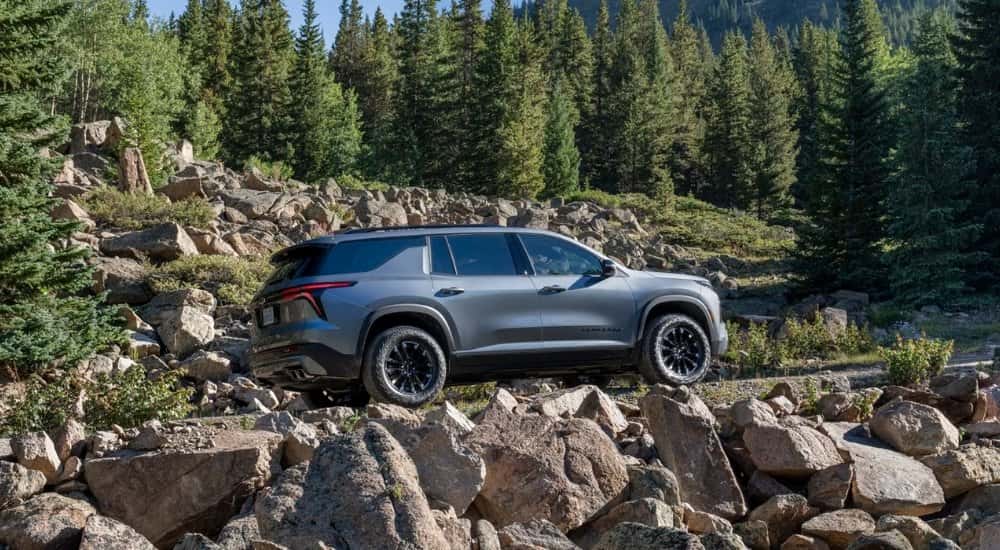 Grey 2026 Chevy Traverse driving up a rocky hill
