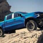 Blue 2026 Chevy Silverado driving up rocks