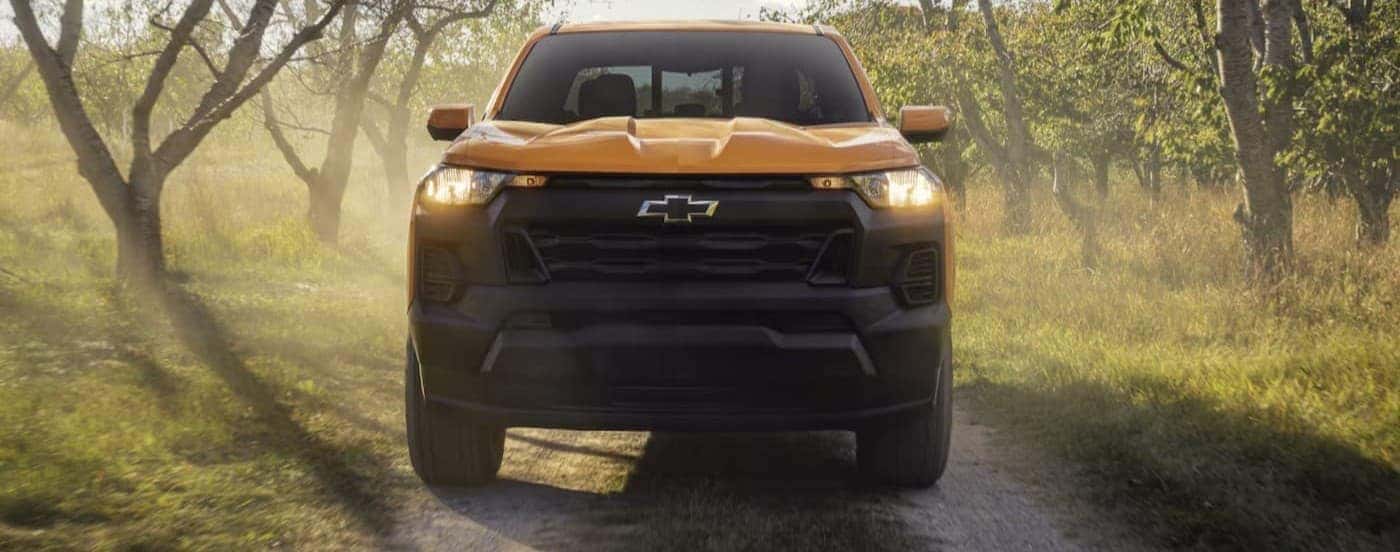 A yellow 2026 Chevy Colorado driving on a trail.