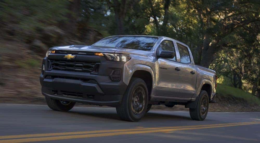 Grey 2026 Chevy Colorado driving down a road