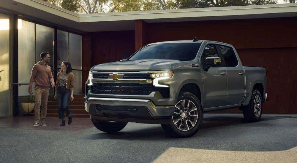 Grey 2026 Chevy Silverado 1500 in driveway with couple