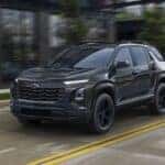Black 2026 Chevy Equinox driving on a city road.