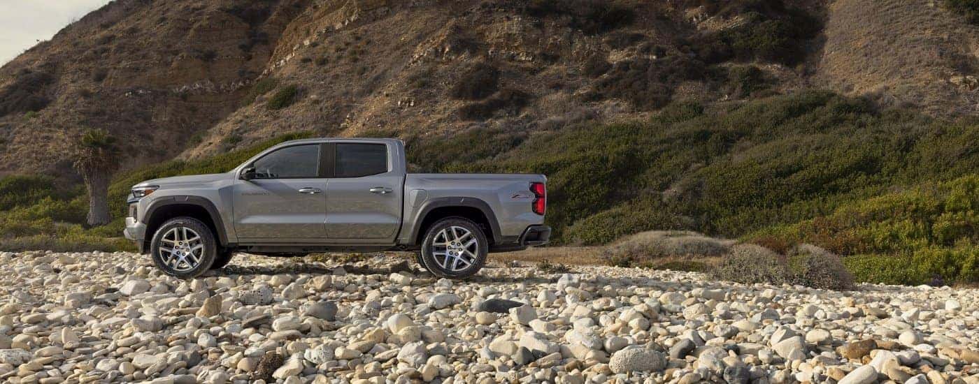 Grey 2026 CHevy Colorado Z71 parked at the bottom of a hill on rocks.