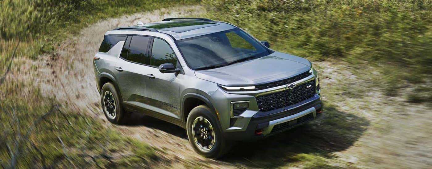A silver 2026 Chevy Traverse driving off-road