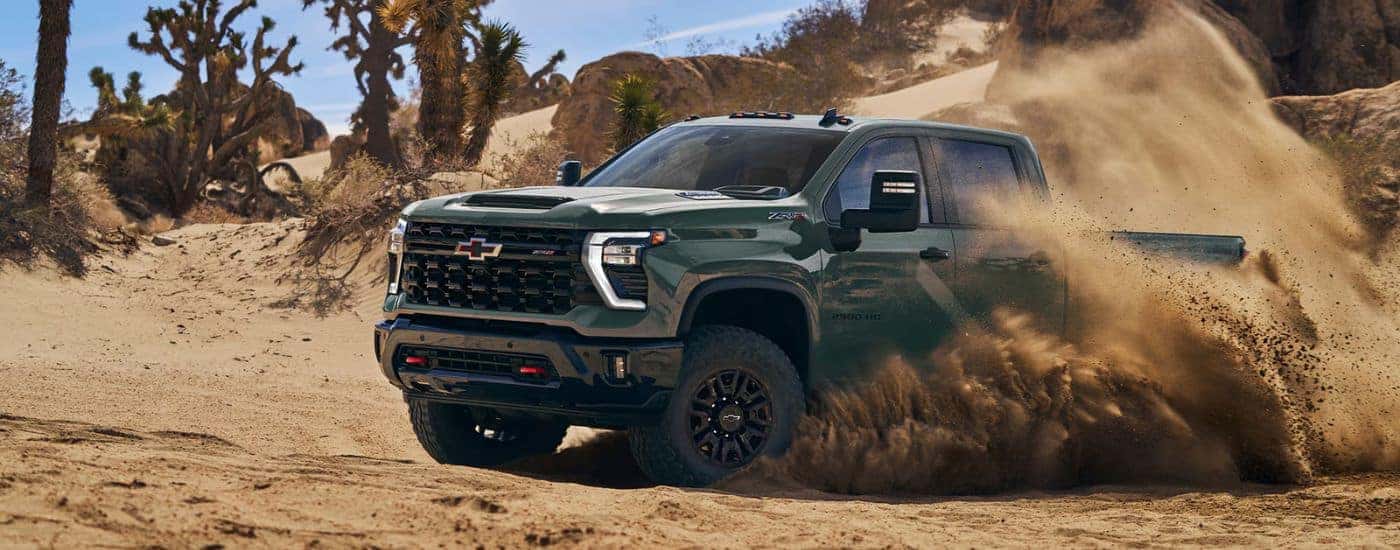 Green 2026 Chevy Silverado 2500 HD off-roading through a desert