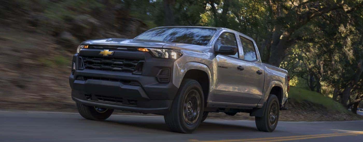Grey 2026 Chevy Colorado driving down a road