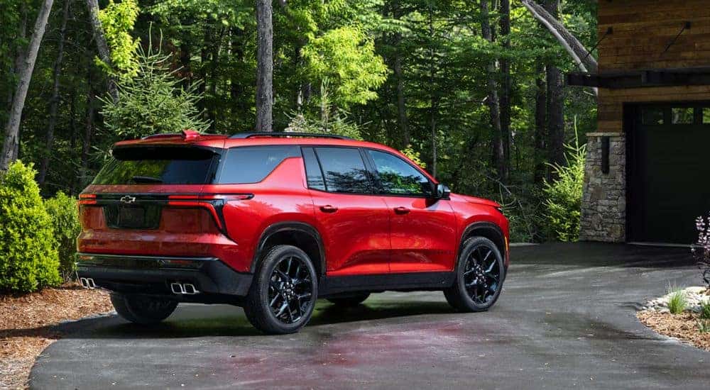 A red 2026 Chevy Traverse RS parked in a driveway.