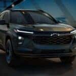 A black 2026 Chevy Trax driving on a bridge.