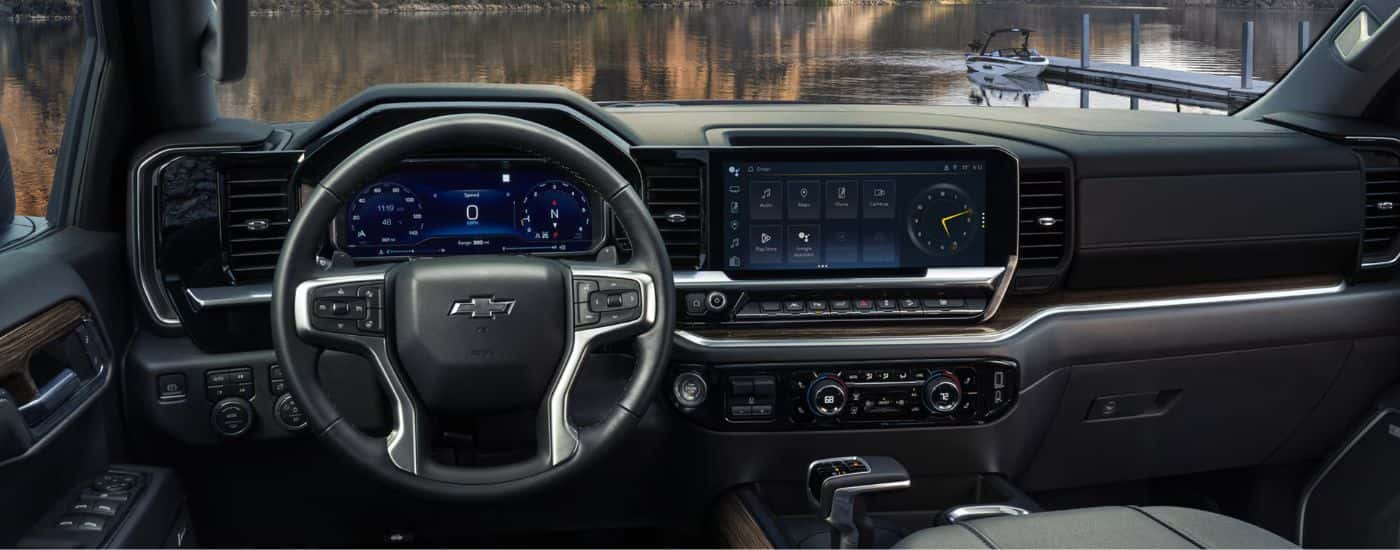 Interior view of a 2026 Chevy Silverado 1500 RST infotainment display, steering wheel & digital gauge cluster.